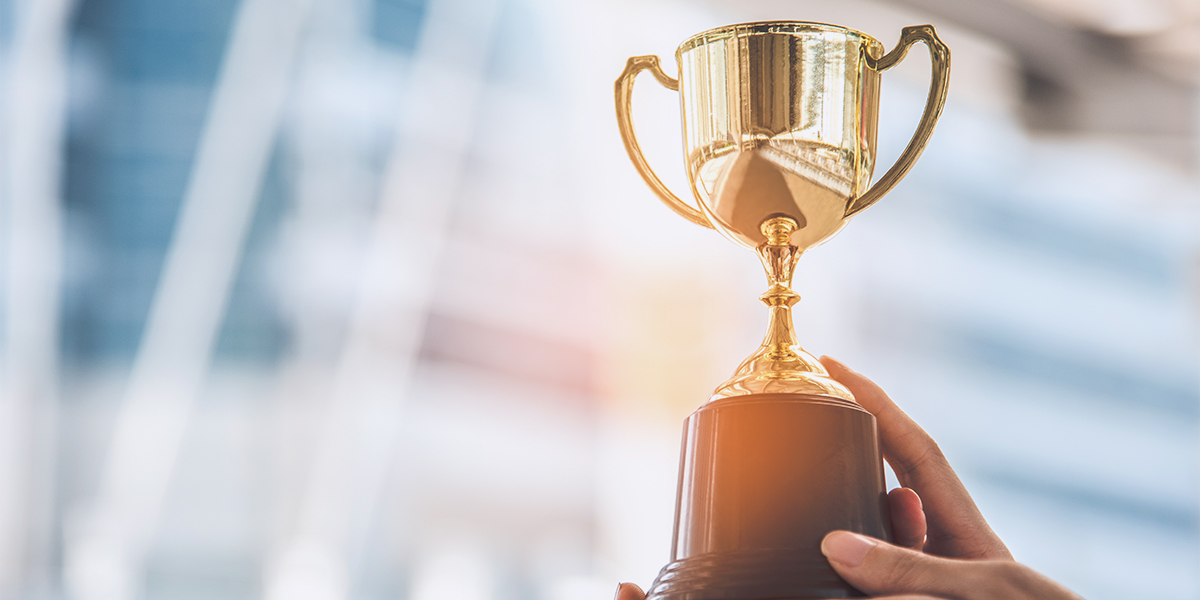 Businesswoman holding up trophy