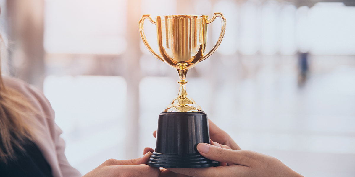 Two businesswomen holding award